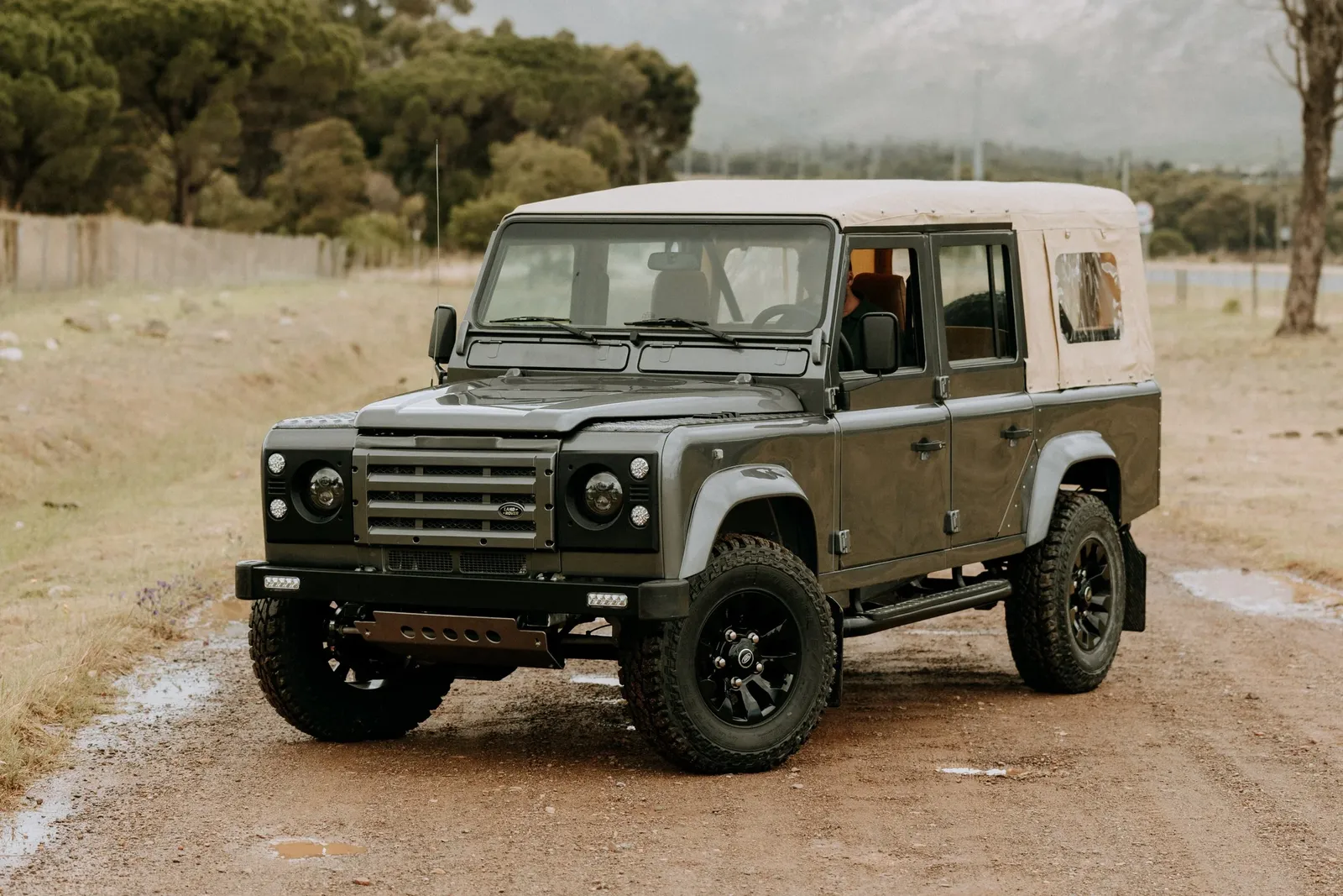 Grey Land Rover Defender double cab pickup with black wheels