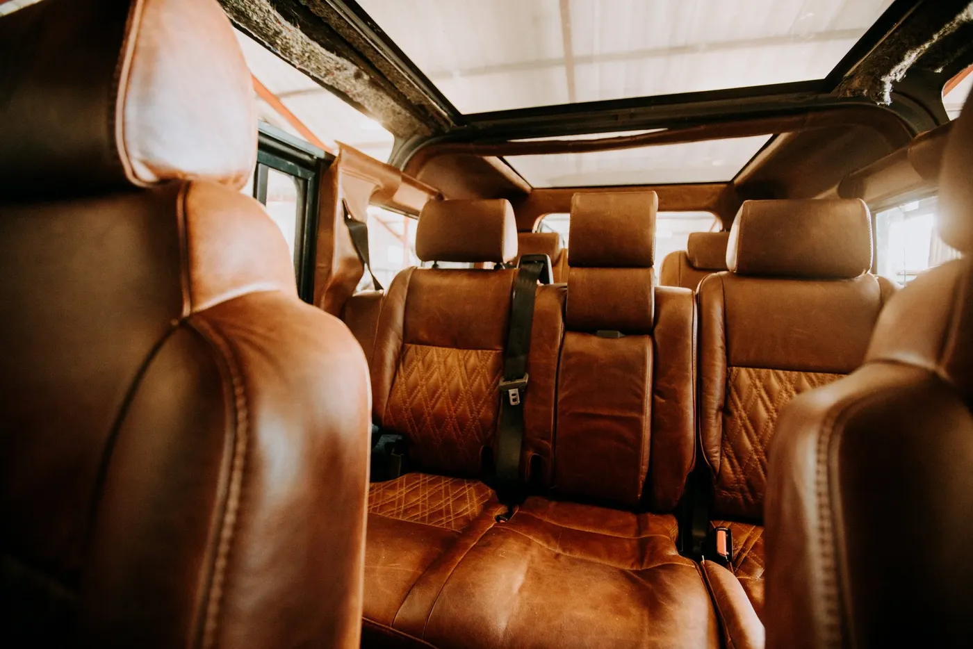 Hand-stitched tan leather Defender interior with three rows of seats